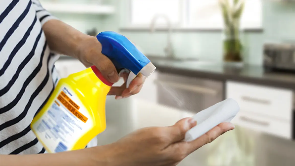 Woman spraying a clothe with cleaner